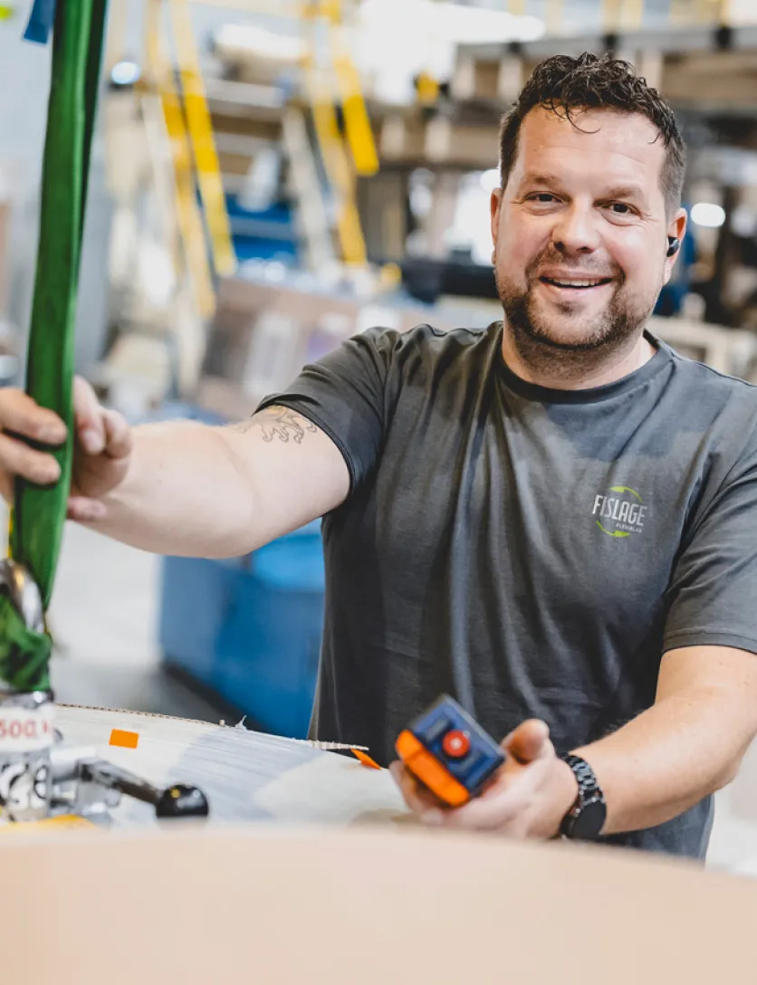 Bild von lächelndem Mitarbeiter an Maschine